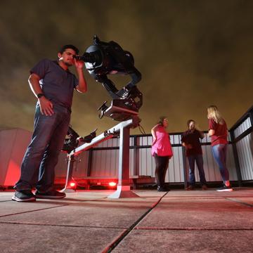 A student looks through a telescope in the 赌钱app可以微信提现 observatory.