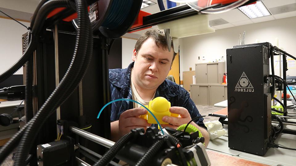 Student using the 3D printer in the MakerLab